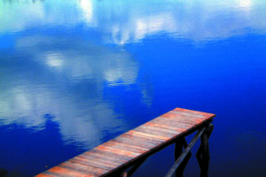 Steg, der in einen blauen See ragt.